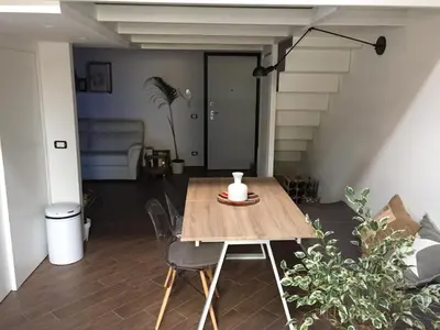 a table and chairs in a room with a staircase at Uloft Apartment Palermo in Palermo
