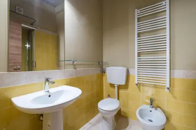 a bathroom with a sink and a toilet and a mirror at Sant'Agostino Apartment by DomuSicily in Palermo