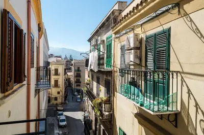 an image of an alley with buildings and balconies at Sant'Agostino Apartment by DomuSicily in Palermo