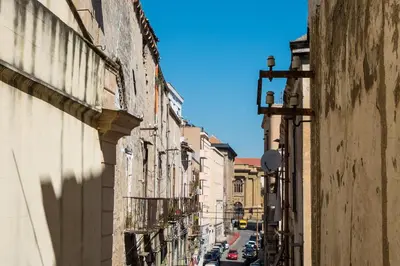 an alley with buildings and cars on a street at Sant'Agostino Apartment by DomuSicily in Palermo