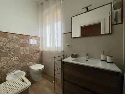 a bathroom with a sink and a toilet and a mirror at Suite de la Sicilienne in Castellammare del Golfo