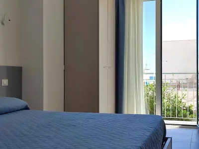 a bedroom with a bed and a large window at B&B Vista Mare in San Vito lo Capo