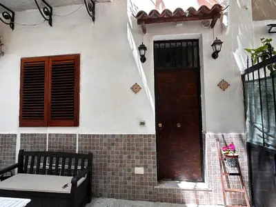 a house with a door and a bench in front of it at Al Cortiletto in Palermo