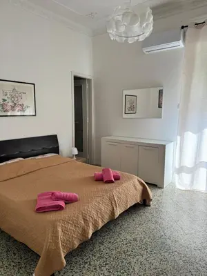 a bedroom with a bed with pink slippers on it at Holiday mondello in Mondello
