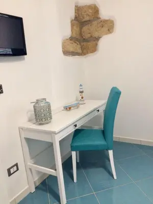 a white desk with a blue chair and a tv at Ca&Sa Sweet Holiday in Cinisi