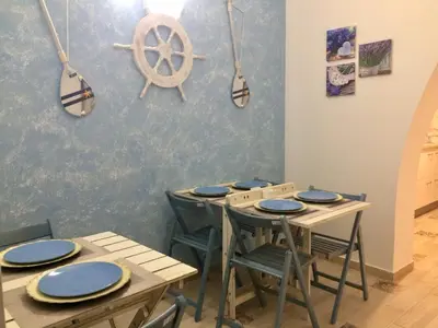 a dining room with tables and chairs with blue plates at Ca&Sa Sweet Holiday in Cinisi