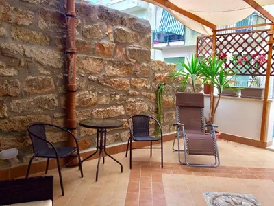 a patio with chairs and a table and a brick wall at Ca&Sa Sweet Holiday in Cinisi