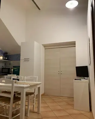 a kitchen with a table and chairs and a door at A 'Du Passi in Castellammare del Golfo
