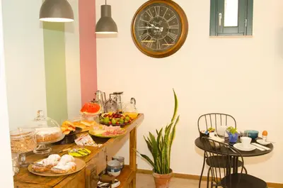 a table with food on it with a clock on the wall at B&B Nencioli in Castellammare del Golfo