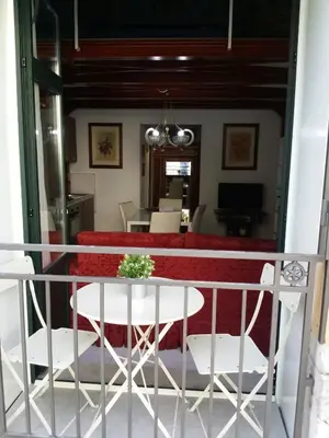 a building with a wooden door and a balcony at La casetta di Tilde in Termini Imerese