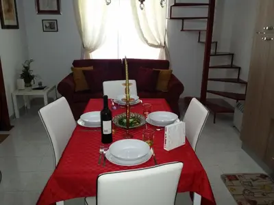 a table and two chairs on a balcony with a window at La casetta di Tilde in Termini Imerese