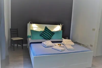 a bed with blue and green pillows and books on it at Dietro al Massimo in Palermo