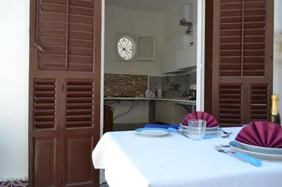 a table with a white table cloth and a clock on the wall at Dietro al Massimo in Palermo