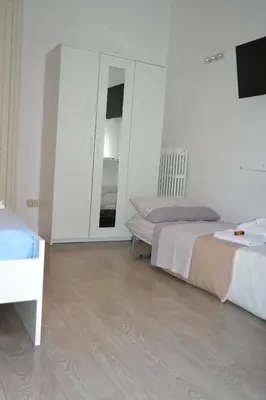 a white room with two beds and a mirror at Dietro al Massimo in Palermo