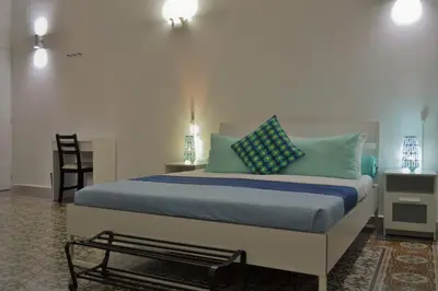 a bedroom with a bed with blue and green pillows at Dietro al Massimo in Palermo