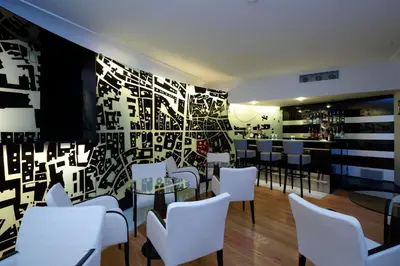 a restaurant with white chairs and a black and white wall at Grand Hotel Piazza Borsa in Palermo