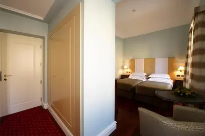 a hotel room with two beds and a table at Grand Hotel Piazza Borsa in Palermo