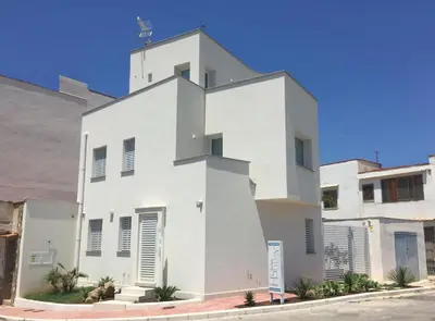 a white building on the side of a street at Charm Holiday in Terrasini