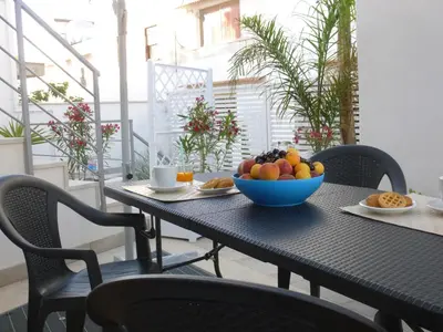 a table with a bowl of fruit on a balcony at Charm Holiday in Terrasini