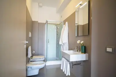 a bathroom with a toilet and a sink and a shower at Enny Camere in Alcamo