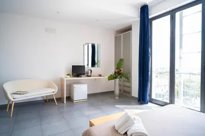a bedroom with a bed and a desk and a chair at Enny Camere in Alcamo