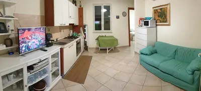 a living room with a blue couch and a kitchen at La Villetta di Leonardo, con piscina privata in Campofelice di Roccella