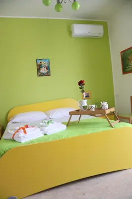 a bedroom with a yellow bed with a table on it at Appartamento Il Gabbiano in Balestrate