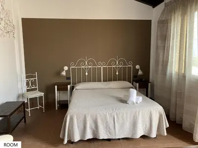 a bedroom with a bed with a white bedspread at Tenute Plaia Agriturismo in Scopello