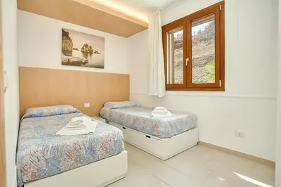 a bedroom with two beds and a window at Villa dell'Artista in Scopello