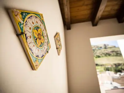 a plate hanging on a wall next to a mirror at Appartamento gli archi a 100 metri dalla spiaggia in Castellammare del Golfo