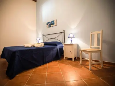 a bedroom with a bed and a chair and a table at Appartamento gli archi a 100 metri dalla spiaggia in Castellammare del Golfo