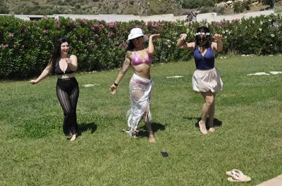three women in costumes standing in the grass at Baglio Dello Zingaro in Scopello