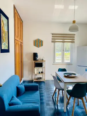 a living room with a blue couch and a table at Villa Eagle in Terrasini