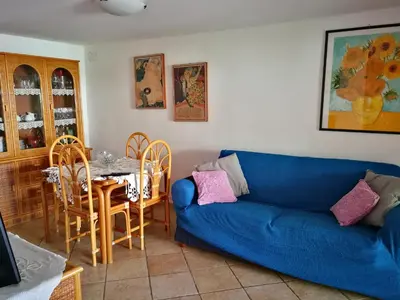 a living room with a blue couch and a table at Villa Caterina in Mondello