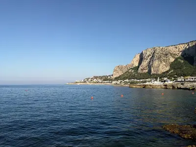 a large body of water next to a mountain at Villa Caterina in Mondello