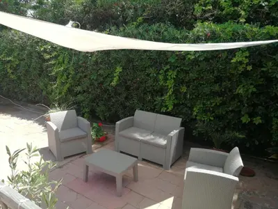 a patio with chairs and a table and a canopy at Villa Caterina in Mondello