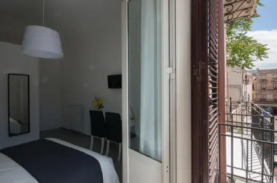 a bedroom with a bed and a balcony at Dietro il Teatro in Palermo