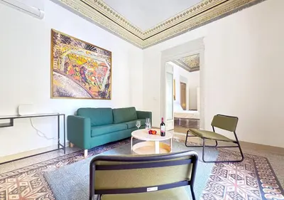 a living room with a blue couch and a table at Solemar Sicilia - Monacò rooms in Palermo