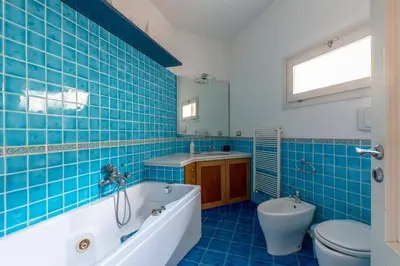 a blue tiled bathroom with a tub and a toilet at Terrazze di San Francesco by Wonderful Italy in Palermo