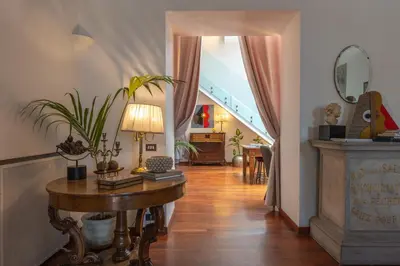 a hallway with a table with a lamp and a staircase at L' Hôtellerie Easy Suites in Palermo