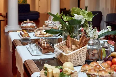 a table filled with food and baskets of bread at L' Hôtellerie Easy Suites in Palermo