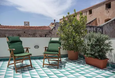 two green chairs sitting on top of a roof at Kalsa Casa di Charme con terrazza by Wonderful Italy in Palermo