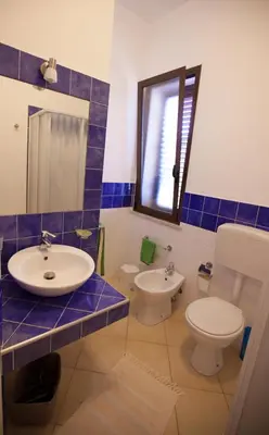 a bathroom with a sink and a toilet and a mirror at Grace's Place in Scopello
