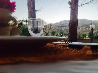 a table with a plate and a wine glass at Grace's Place in Scopello
