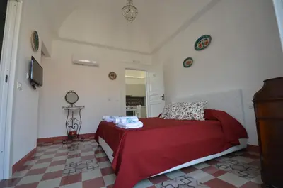 a bedroom with a bed with a red blanket at Palazzo Torre Apartment in Palermo
