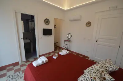 a bedroom with a red bed with towels on it at Palazzo Torre Apartment in Palermo