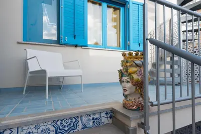 a chair and a vase sitting on a balcony at B&B Reef and Dream in San Vito lo Capo