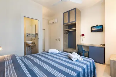 a bedroom with a blue and white bed with towels on it at B&B Reef and Dream in San Vito lo Capo