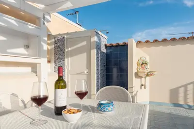 a table with a bottle of wine and two glasses at B&B Reef and Dream in San Vito lo Capo