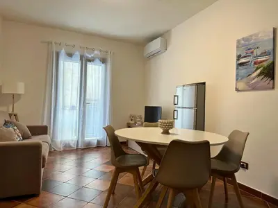 a living room with a table and chairs at Appartamenti-Residence Al Massimo in Palermo